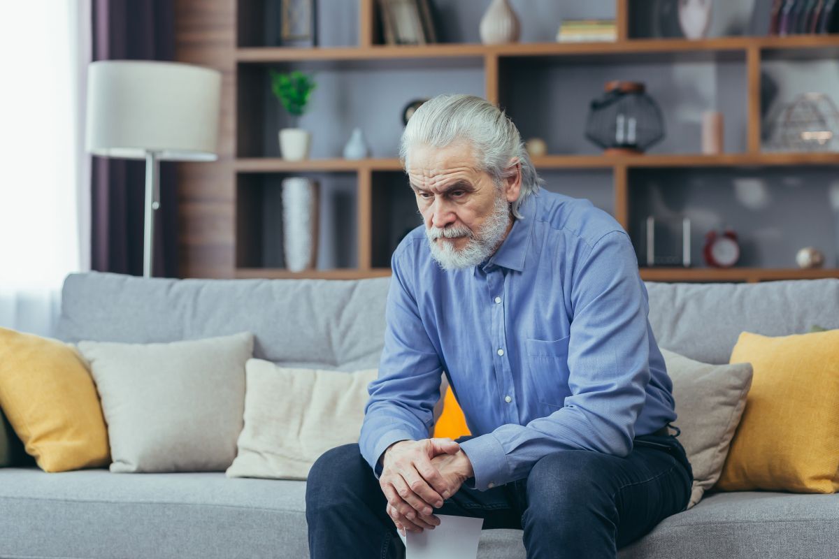 Homem sentado no sofá refletindo sobre o IPP grau 3 tratamento.